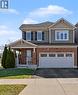 Two-story residence featuring a brick and siding exterior, an integrated two-car garage with a panel door, a covered front porch with white railings, and a paved driveway - 60 Postmaster Drive, Kitchener, ON  - Outdoor With Facade 