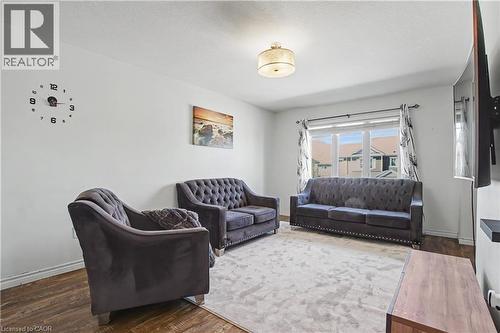 Bright living area featuring wood-finish flooring, white baseboards, and a large window with white trim - 60 Postmaster Drive, Kitchener, ON - Indoor Photo Showing Other Room