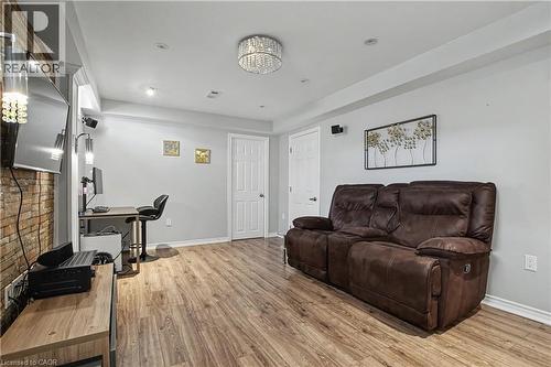 Spacious interior featuring wood-finish flooring, light gray walls, white trim, and a decorative crystal chandelier - 60 Postmaster Drive, Kitchener, ON - Indoor