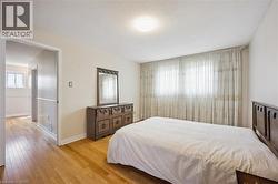 Hardwood flooring and neutral wall tones define this bedroom space - 