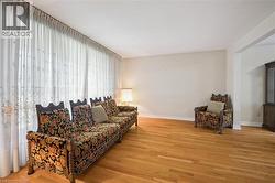 Spacious interior featuring wood-finish flooring, light-toned walls, and white baseboards - 