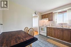 Kitchen featuring wood cabinetry, white appliances, and a double basin sink - 