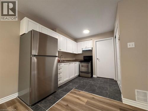Kitchen with stainless steel appliances, white cabinetry, and dark countertop - 44 Walnut Street Unit# E01, Kitchener, ON - Indoor Photo Showing Kitchen