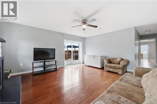 Spacious living area featuring wood-finish flooring, a ceiling fan, and sliding glass doors providing access to the exterior - 2934 Baker Road, Niagara Falls, ON - Indoor Photo Showing Living Room