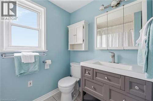 Bathroom featuring a contemporary gray vanity with an integrated sink, a mirrored medicine cabinet, and a white wall-mounted cabinet - 2934 Baker Road, Niagara Falls, ON - Indoor Photo Showing Bathroom