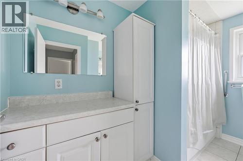 Vanity area featuring a light-colored countertop, white cabinetry with silver-tone hardware, and an attached wall mirror - 2934 Baker Road, Niagara Falls, ON - Indoor Photo Showing Bathroom