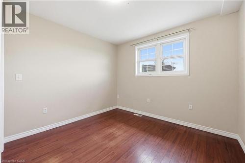 Interior room featuring warm wood-finish flooring, light-toned walls, and a white-trimmed window - 2934 Baker Road, Niagara Falls, ON - Indoor Photo Showing Other Room