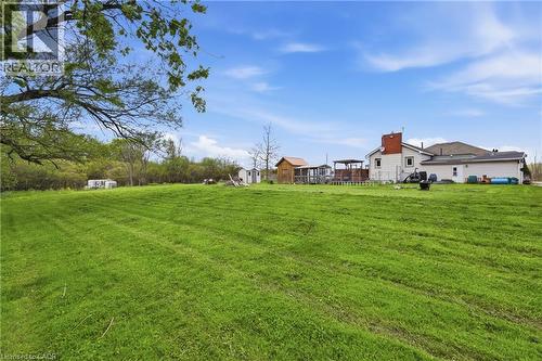 Expansive green lawn with a tree canopy, featuring a house with an attached deck, and multiple outbuildings - 2934 Baker Road, Niagara Falls, ON - Outdoor