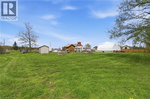 Expansive green lawn with a white storage shed and a large hoop house structure - 2934 Baker Road, Niagara Falls, ON - Outdoor