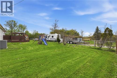 Expansive green lawn with a wooden deck featuring a pergola, and a storage shed - 2934 Baker Road, Niagara Falls, ON - Outdoor