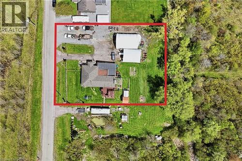 Aerial view of a rectangular property featuring a single-story residence with a brown shingled roof, extensive green lawn areas, and mature trees bordering the perimeter - 2934 Baker Road, Niagara Falls, ON - Outdoor With View