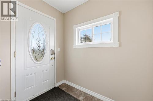 Entryway featuring a white paneled door with leaded glass oval insert, gold-tone hardware, and a digital lock - 2934 Baker Road, Niagara Falls, ON - Indoor Photo Showing Other Room