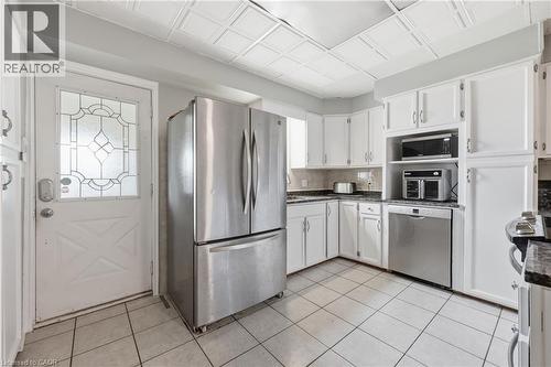 Kitchen featuring white cabinetry, granite countertops, stainless steel appliances, and tile flooring - 2934 Baker Road, Niagara Falls, ON - Indoor Photo Showing Kitchen With Stainless Steel Kitchen