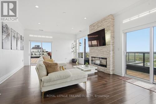 Upper: Living Room with Access to the Terrace - 1403 - 240 Villagewalk Boulevard, London North (North R), ON - Indoor Photo Showing Living Room With Fireplace