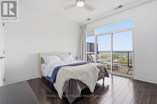 Lower: Bedroom with Doors to Private Balcony - 1403 - 240 Villagewalk Boulevard, London North (North R), ON - Indoor Photo Showing Bedroom