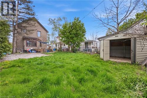 Expansive grassy yard with a detached storage shed featuring double swing-out doors - 54 Evan Street, Welland, ON - Outdoor