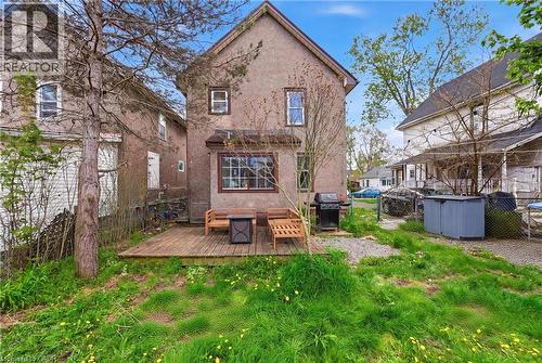 Rear exterior featuring a wood deck, stucco siding, and multiple windows - 54 Evan Street, Welland, ON - Outdoor