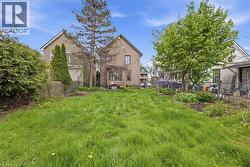 Expansive green space featuring mature trees and a chain-link fence border - 