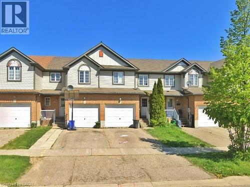 Townhome exterior featuring brick and siding construction, individual garage access, and a prominent front entrance with a porch - 193 Prosperity Drive, Kitchener, ON - Outdoor With Facade