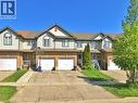 Townhome exterior featuring brick and siding construction, individual garage access, and a prominent front entrance with a porch - 193 Prosperity Drive, Kitchener, ON  - Outdoor With Facade 