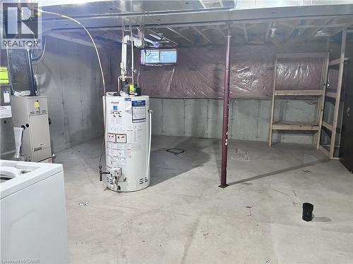Unfinished basement offering concrete flooring, exposed ceiling joists, and a utility area with water heater and furnace - 193 Prosperity Drive, Kitchener, ON - Indoor Photo Showing Laundry Room