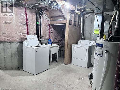 Dedicated laundry area with concrete flooring, utility sink, and visible insulation - 193 Prosperity Drive, Kitchener, ON - Indoor Photo Showing Laundry Room