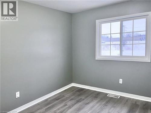 Windowed interior space featuring wood-finish flooring, light gray walls, and white baseboards - 193 Prosperity Drive, Kitchener, ON - Indoor Photo Showing Other Room