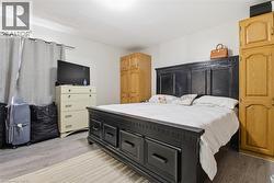 Spacious room featuring wood-finish flooring, light-toned walls, and recessed lighting - 