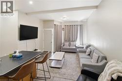 Open-concept living area with light-toned walls and wood-finish flooring - 