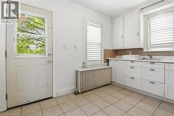 Kitchen with white cabinetry, a stainless steel sink, and light-toned countertop - 