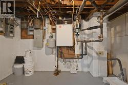 Basement utility area featuring a wall-mounted boiler system and extensive plumbing - 