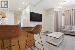 Open-concept living space featuring a kitchen peninsula with a dark countertop, recessed lighting, and a neutral color palette - 