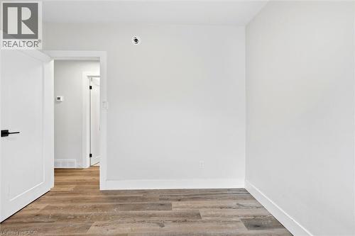 Interior space featuring wood-finish flooring, white walls, and white trim - 16 Ronaldshay Avenue, Hamilton, ON - Indoor Photo Showing Other Room