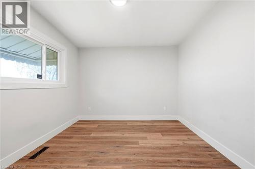 Neutral tone walls with wood-finish flooring - 16 Ronaldshay Avenue, Hamilton, ON - Indoor Photo Showing Other Room