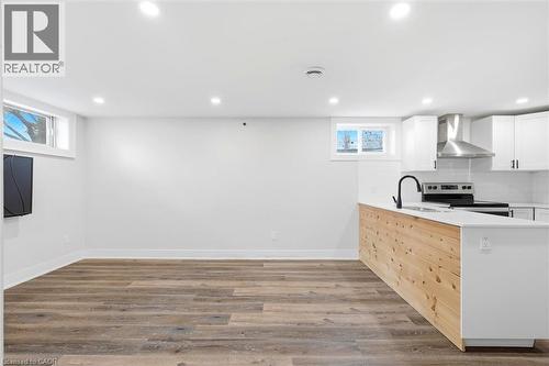 Open-concept living area featuring wood-finish flooring, recessed lighting, and bright white walls - 16 Ronaldshay Avenue, Hamilton, ON - Indoor