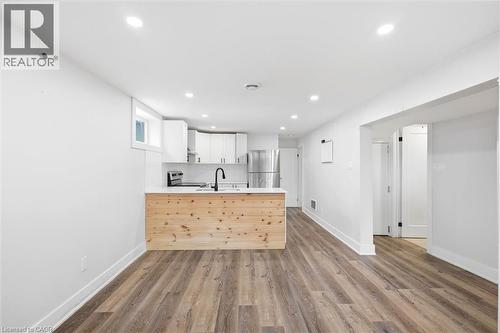 Open-concept living space featuring wood-finish flooring and recessed lighting - 16 Ronaldshay Avenue, Hamilton, ON - Indoor