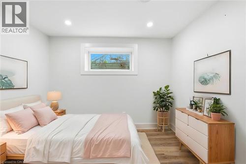 Bedroom featuring a window with natural light, recessed ceiling lighting, light-toned walls, and wood-finish flooring - 16 Ronaldshay Avenue, Hamilton, ON - Indoor Photo Showing Bedroom