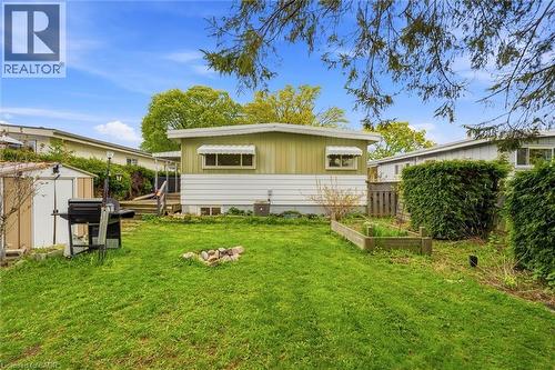 Spacious backyard with a manicured lawn, a raised garden bed, and a storage shed - 16 Ronaldshay Avenue, Hamilton, ON - Outdoor