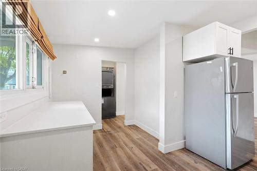 Kitchen area featuring white cabinetry, light-colored countertops, and wood-finish flooring - 16 Ronaldshay Avenue, Hamilton, ON - Indoor