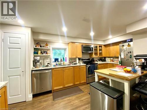 Kitchen featuring wood-finish flooring, light wood cabinetry, white countertops, and stainless steel appliances - 358 Dundas Street E, Hamilton, ON - Indoor Photo Showing Kitchen