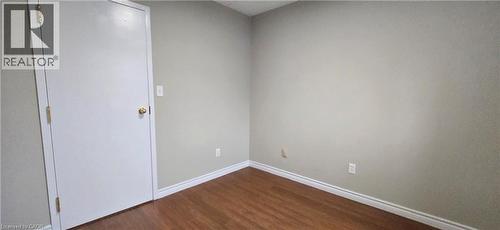 Room featuring wood-finish flooring, light neutral wall paint, and white baseboards - 274 E Highland Road E Unit# 10, Kitchener, ON - Indoor Photo Showing Other Room