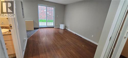 Spacious room featuring wood-finish flooring, neutral wall tones, and white baseboards - 274 E Highland Road E Unit# 10, Kitchener, ON - Indoor Photo Showing Other Room