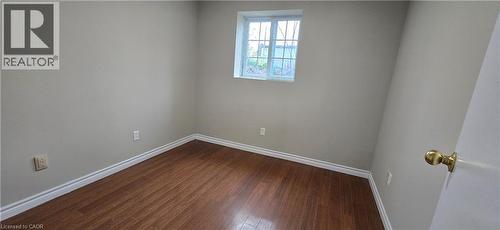 Room featuring wood-finish flooring, light neutral wall paint, and white baseboards - 274 E Highland Road E Unit# 10, Kitchener, ON - Indoor Photo Showing Other Room