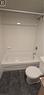 Bathroom featuring a white tub, chrome fixtures, white subway tile surround, and dark-toned floor tiles - 274 E Highland Road E Unit# 10, Kitchener, ON  - Indoor Photo Showing Bathroom 
