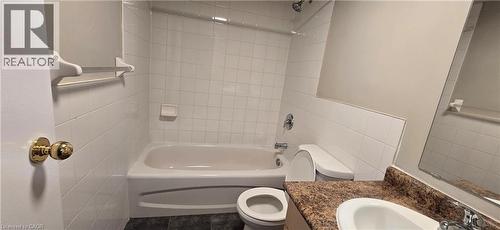 Full bathroom featuring a white bathtub/shower combination with tile surround, a white toilet, and a vanity with a white sink and a brown speckled countertop - 274 E Highland Road E Unit# 10, Kitchener, ON - Indoor Photo Showing Bathroom