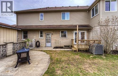 Rear exterior featuring a concrete patio, brick and siding facade, and a wood deck with double glass doors - 716 Westminster Drive S Unit# Lower, Cambridge, ON - Outdoor With Exterior