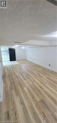 Spacious open-concept room featuring wide-plank wood-finish flooring and bright white walls - 716 Westminster Drive S Unit# Lower, Cambridge, ON - Indoor Photo Showing Other Room