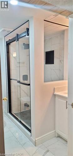Bathroom featuring a frameless glass shower enclosure with matte black hardware, white tile flooring, white vanity with integrated sink, and recessed lighting - 716 Westminster Drive S Unit# Lower, Cambridge, ON - Indoor Photo Showing Other Room