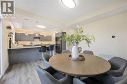 Open-concept kitchen and dining area featuring light wood-finish flooring, recessed lighting, and a kitchen island with seating - 