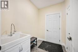 Utility sink with chrome gooseneck faucet and white cabinetry - 